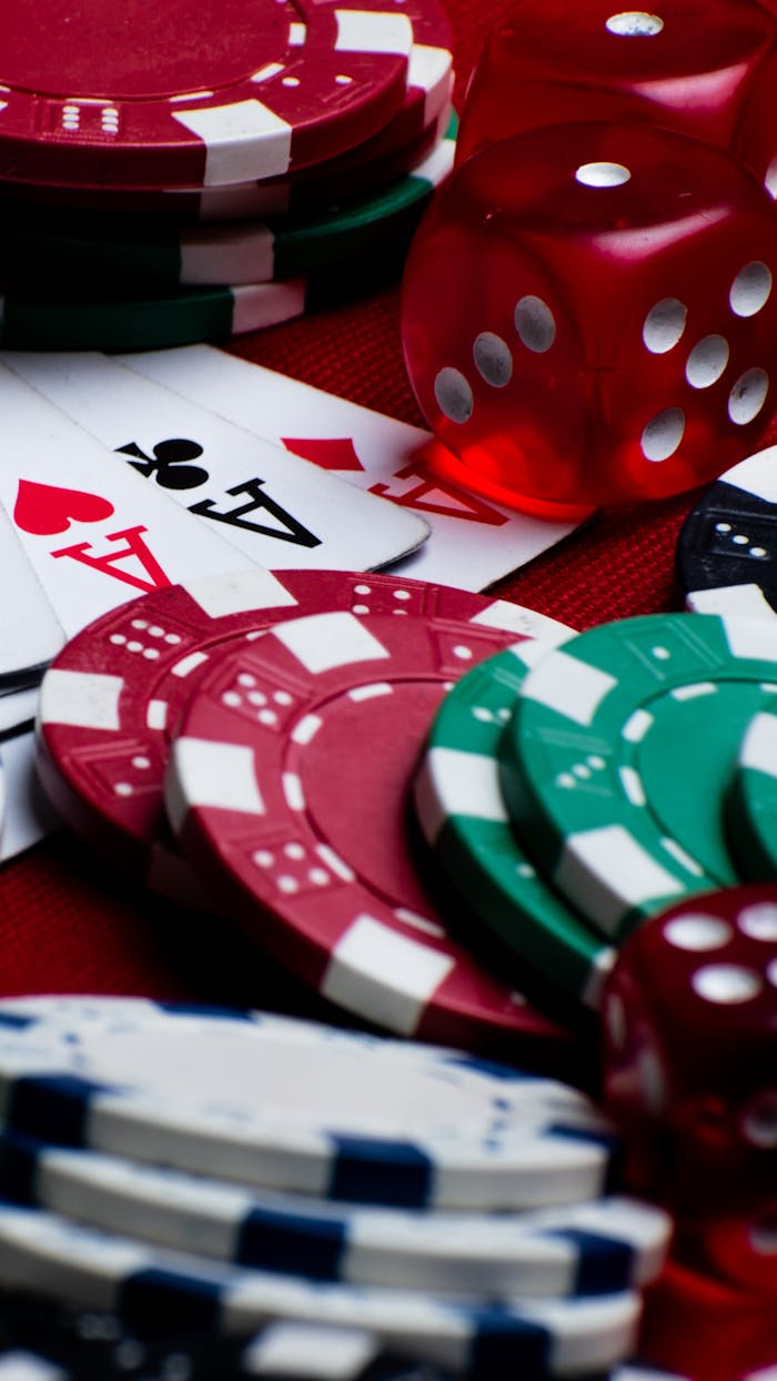 Colorful assortments of poker chips, dice, and playing cards create a vivid casino scene.